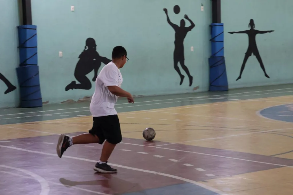 Crianças jogando futebol no ginásio